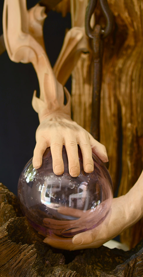 Détails des mains et de la boule en verre de la sculpture